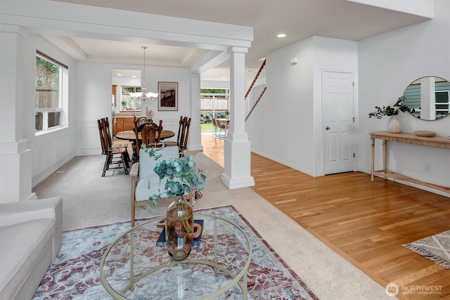 interior space featuring plenty of natural light, stairs, a tray ceiling, and light wood-style flooring