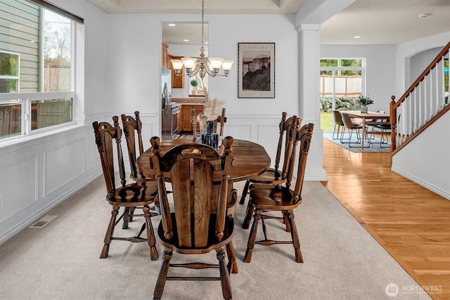 dining area featuring a chandelier, recessed lighting, a decorative wall, visible vents, and light wood finished floors