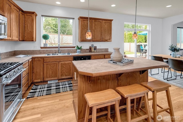 kitchen with appliances with stainless steel finishes, brown cabinetry, and a sink