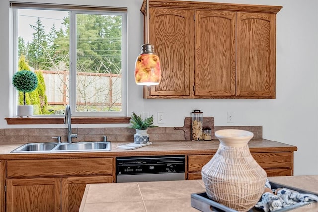 kitchen featuring dishwasher, tile countertops, a sink, and brown cabinets