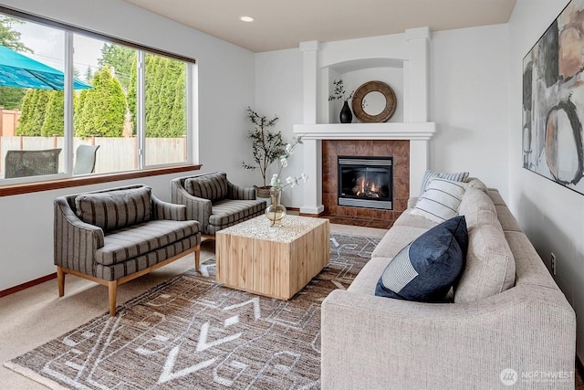 carpeted living area featuring recessed lighting, a tiled fireplace, and baseboards