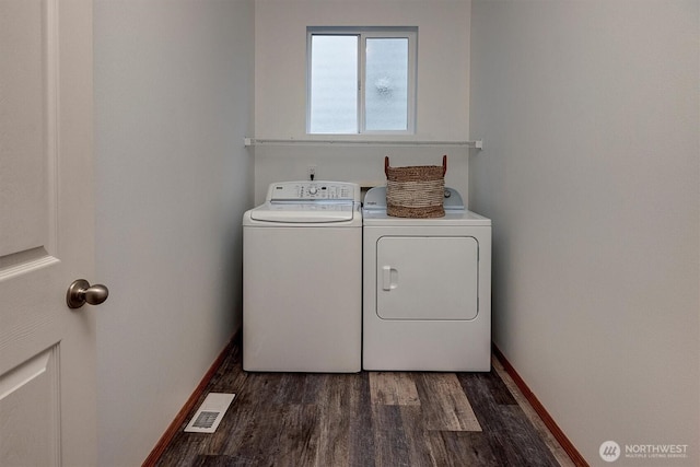 washroom with laundry area, dark wood-style flooring, visible vents, baseboards, and washer and clothes dryer