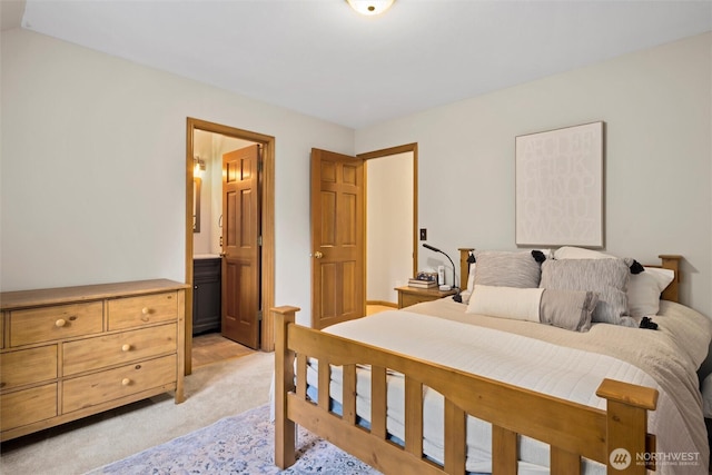 bedroom with light carpet and ensuite bathroom