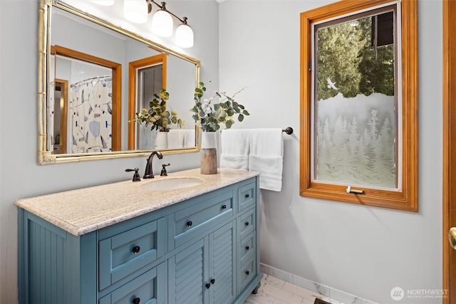 full bathroom featuring marble finish floor, vanity, and baseboards