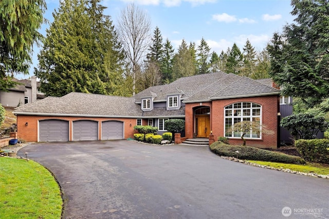 view of front facade with brick siding, driveway, and an attached garage