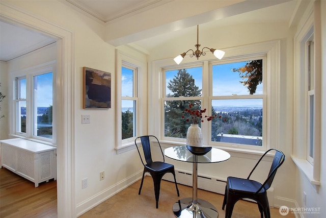 dining area with a notable chandelier, baseboard heating, ornamental molding, light wood-type flooring, and baseboards