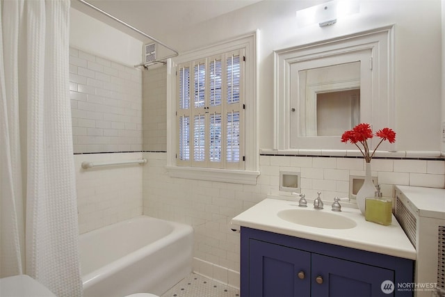 full bathroom with vanity, tile walls, and shower / bathtub combination with curtain