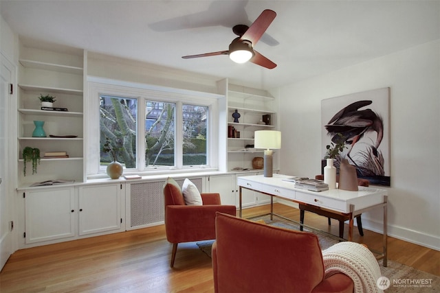 office space featuring baseboards, light wood-style flooring, and a ceiling fan