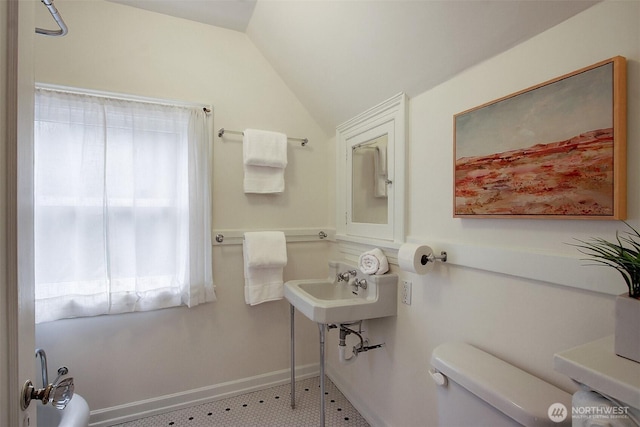 half bath featuring lofted ceiling, a sink, and toilet