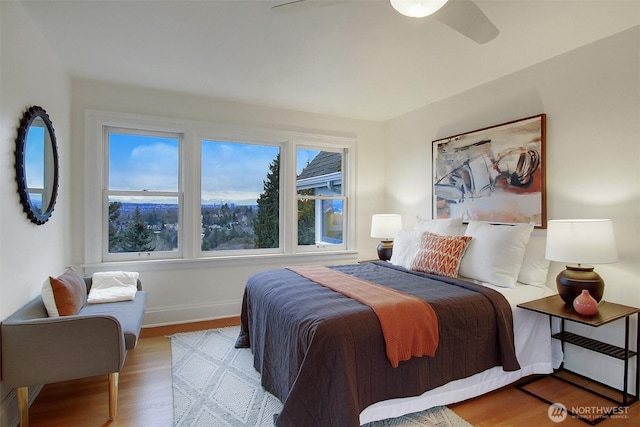 bedroom with light wood finished floors, multiple windows, and baseboards