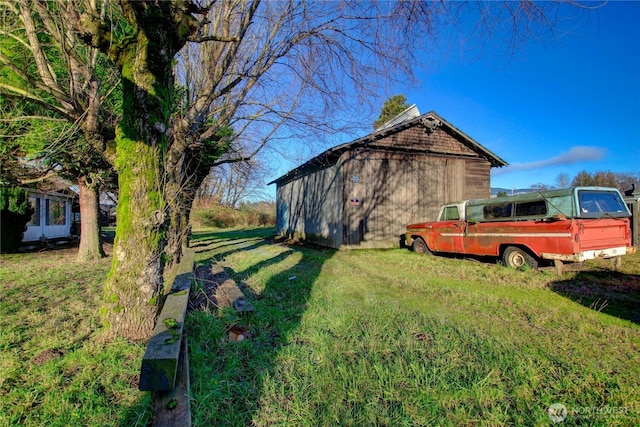 view of property exterior with a lawn and an outbuilding