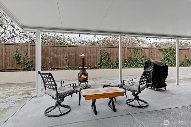 view of patio with a fenced backyard, a fire pit, and grilling area