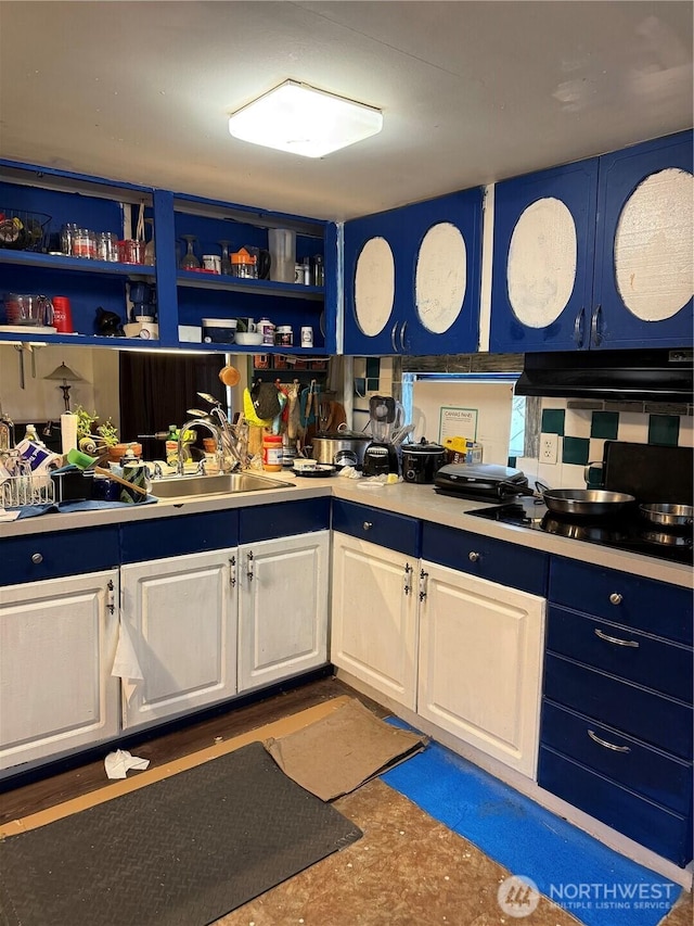 kitchen with white cabinets, blue cabinets, black gas cooktop, light countertops, and under cabinet range hood