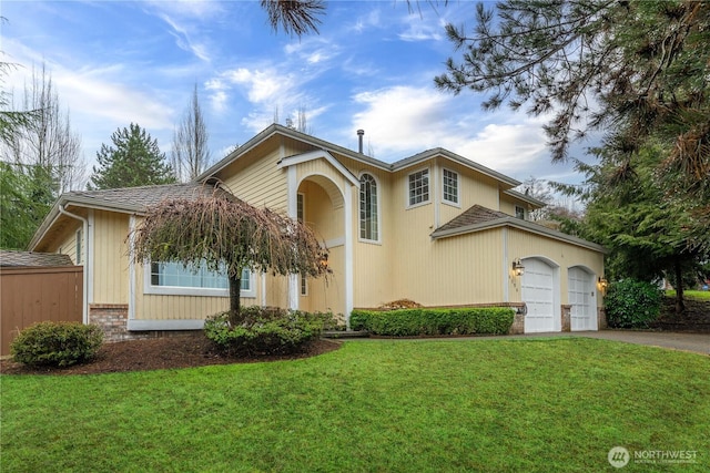 view of front of property with brick siding, driveway, an attached garage, and a front lawn