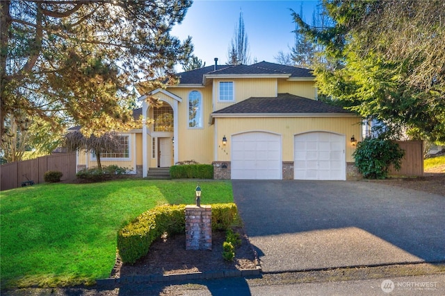 view of front of home with a front lawn, aphalt driveway, fence, a shingled roof, and a garage