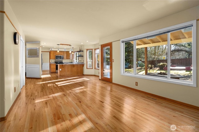 unfurnished living room featuring recessed lighting, light wood-type flooring, baseboards, and visible vents