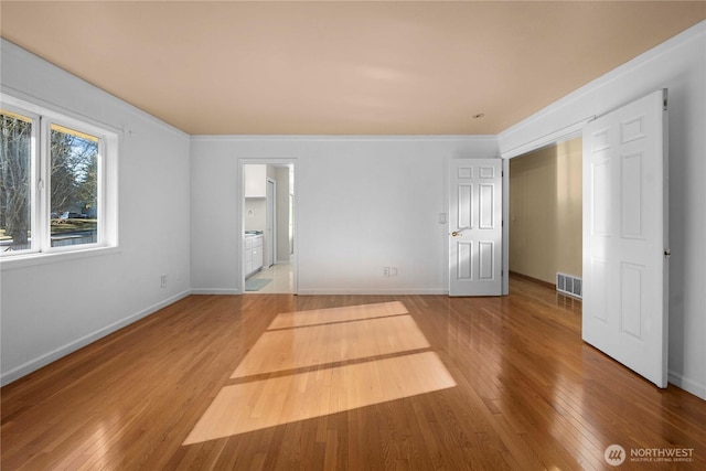 unfurnished bedroom featuring baseboards, visible vents, and wood-type flooring