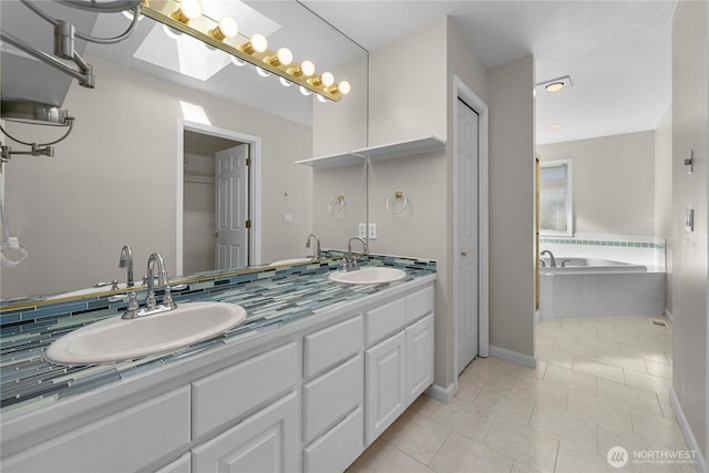 bathroom with a sink, tiled bath, double vanity, and tile patterned flooring