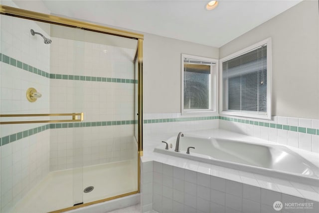 bathroom featuring a stall shower and a bath