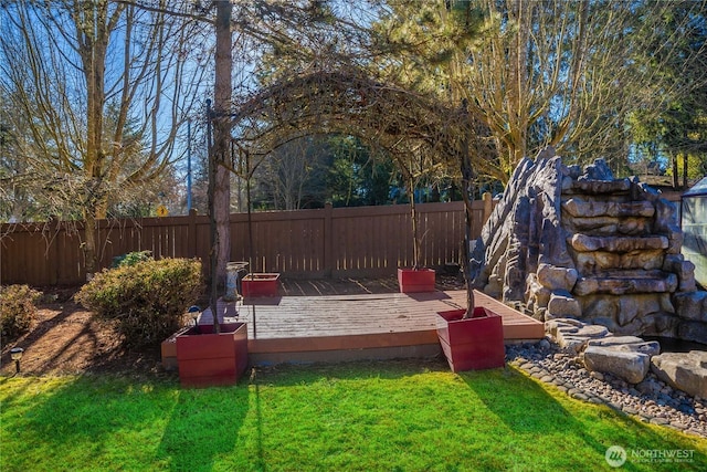 deck featuring a yard and a fenced backyard