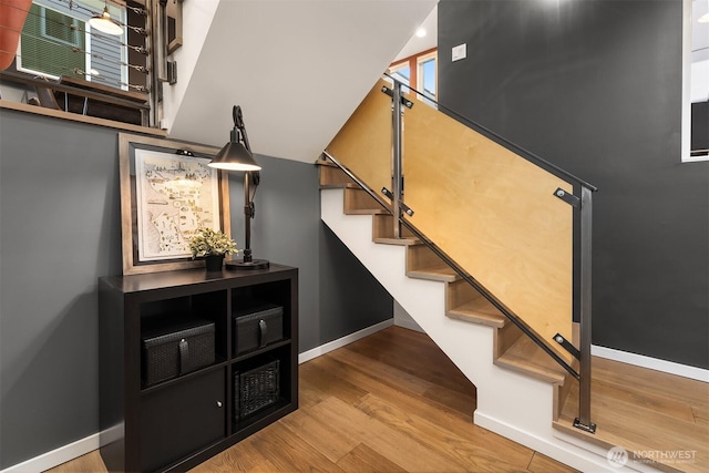 staircase featuring baseboards and wood finished floors