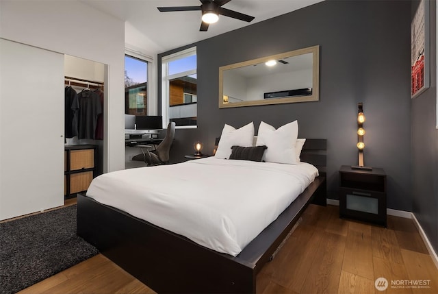 bedroom featuring a closet, baseboards, and wood finished floors