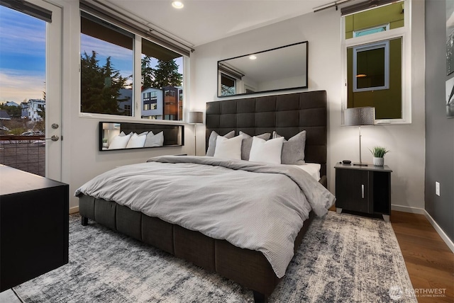 bedroom with baseboards, wood finished floors, and recessed lighting