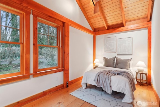 bedroom featuring vaulted ceiling with beams, wooden ceiling, baseboards, and light wood-style floors