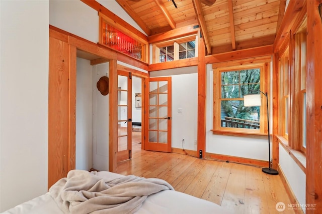 bedroom with baseboards, lofted ceiling with beams, wooden ceiling, hardwood / wood-style floors, and french doors