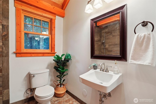 bathroom featuring baseboards, a sink, and toilet