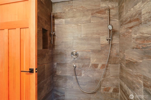 interior details featuring tiled shower