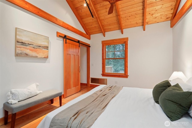 bedroom with wood finished floors, wood ceiling, vaulted ceiling with beams, and a barn door