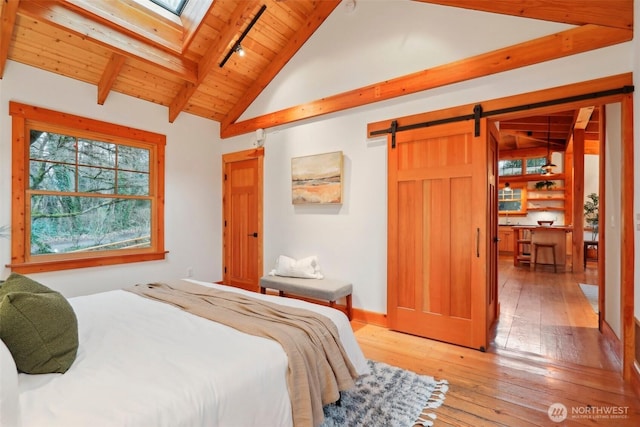 bedroom with a skylight, a barn door, wooden ceiling, wood-type flooring, and beamed ceiling