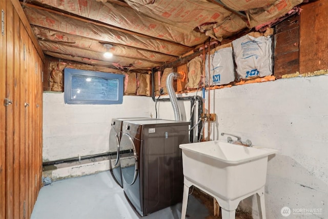 washroom with laundry area, washing machine and dryer, and a sink