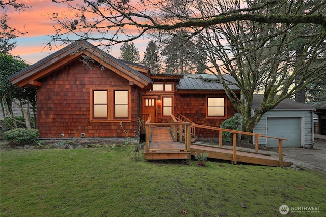 view of front of house with a garage, a yard, a deck, and driveway