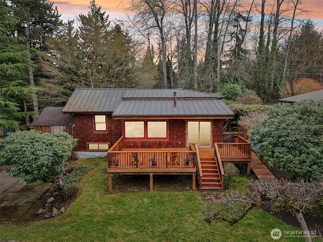 back of property with metal roof, stairs, a yard, a wooden deck, and a standing seam roof