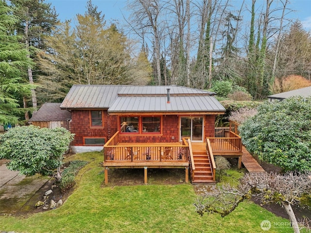 rear view of property with a lawn, stairway, metal roof, a standing seam roof, and a wooden deck