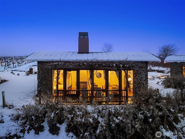 snow covered property with a chimney