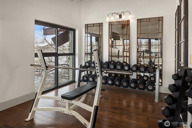 workout area with baseboards and dark wood-style flooring