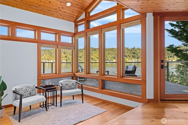 sunroom with a water view, baseboards, and a healthy amount of sunlight