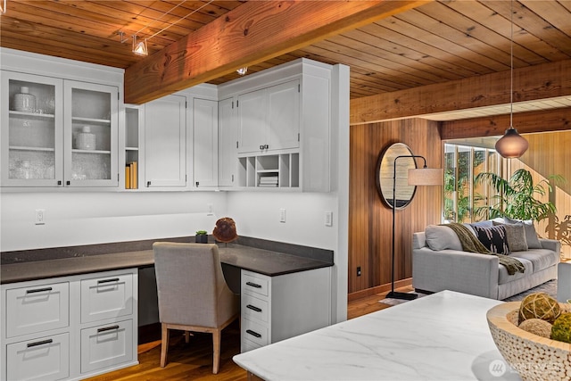 kitchen with wood ceiling, wood walls, built in desk, and wood finished floors