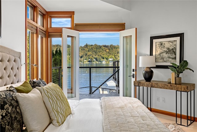 bedroom with a water view and access to exterior