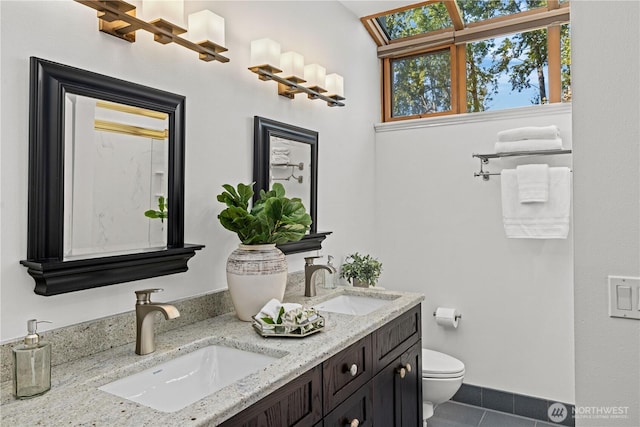 full bathroom featuring a sink, tile patterned floors, toilet, and double vanity