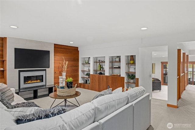 living area with a large fireplace, light carpet, and recessed lighting