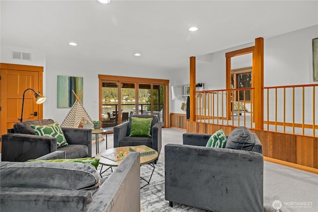 living area featuring recessed lighting, visible vents, and light carpet