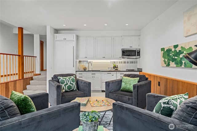 living room featuring wood walls, wainscoting, and recessed lighting