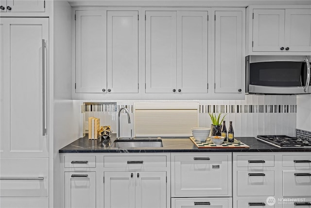 kitchen with a sink, white cabinets, and stainless steel appliances