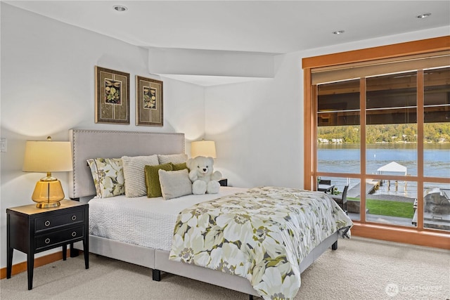 carpeted bedroom with a water view and recessed lighting