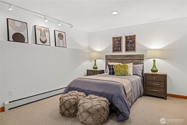carpeted bedroom with baseboards, a baseboard heating unit, and rail lighting