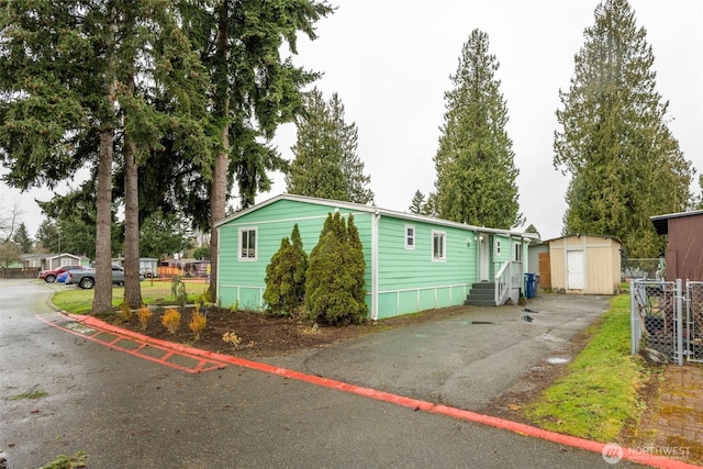 exterior space featuring a shed, an outdoor structure, and fence